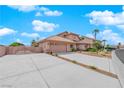 Two-story house with a tan exterior, a two-car garage, and a gated driveway at 319 Hidden Highlands Dr, Las Vegas, NV 89110