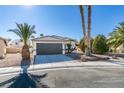 Single story home with a two car garage and desert landscaping at 7305 Backstretch Ave, Las Vegas, NV 89130