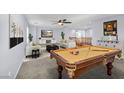 Game room with pool table, comfortable seating, and a large TV at 7479 Lassen Peak Cir, Las Vegas, NV 89149