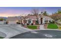 House exterior at dusk with stone accents and manicured lawn at 10032 Fox Springs Dr, Las Vegas, NV 89117