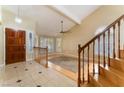 Inviting living area featuring tile floors, a wooden staircase, and sunlit windows with plantation shutters at 2112 Brighton Shore St, Las Vegas, NV 89128