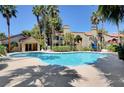 Community pool with palm trees and surrounding patio at 3145 E Flamingo Rd # 2122, Las Vegas, NV 89121