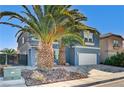 Two-story house with gray exterior, stone driveway, and palm trees at 6336 Fence Post St, Las Vegas, NV 89148