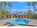 Community pool with lounge chairs and palm trees at 8212 Opal Falls St, North Las Vegas, NV 89085