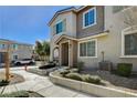 Front view of a two-story townhome with a walkway and landscaping at 8486 Insignia Ave # 101, Las Vegas, NV 89178