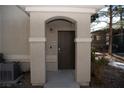 Building entryway with arched entry and dark brown door at 9050 W Warm Springs Rd # 2049, Las Vegas, NV 89148