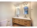 Bathroom with light wood double vanity, black matte fixtures, and arched mirrors at 104 Temple Dr, Las Vegas, NV 89107