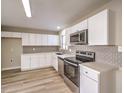 Updated kitchen with white cabinets, stainless steel appliances, and wood look flooring at 104 Temple Dr, Las Vegas, NV 89107