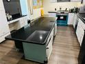 Kitchen with large black countertop island and teal cabinets at 1695 Westwind Rd, Las Vegas, NV 89146