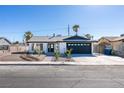 Remodeled single story home with dark gray garage door and landscaped yard at 2157 Wagonwheel Ave, Las Vegas, NV 89119