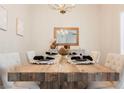 Bright dining room with a rustic wood table and modern chandelier at 3105 Birdwood Dr, Las Vegas, NV 89134