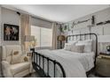 Bedroom with a metal bed frame and neutral color scheme at 330 Shadybrook Ln # D, Las Vegas, NV 89107