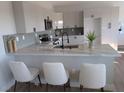 Modern kitchen with breakfast bar, white shaker cabinets and quartz countertop at 3414 Mount Charleston Dr, Pahrump, NV 89048