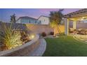 Landscaped backyard with a water feature and covered patio at 3484 Bradano Ln, Henderson, NV 89044