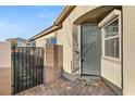 Gray front door with a welcome mat and side gate at 3484 Bradano Ln, Henderson, NV 89044