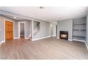 Spacious living room with wood-look floors, fireplace, staircase, and bright window at 3802 Terrazzo Ave, Las Vegas, NV 89115