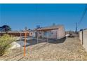 Large backyard with gravel, covered patio, and chain link fence at 4524 Fulton Pl, Las Vegas, NV 89107