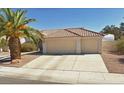 Attached three-car garage with driveway and desert landscaping at 4624 Standing Bluff Way, Las Vegas, NV 89130