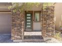 Front entry with stone pillars and a modern door at 712 Rogue Wave St, Las Vegas, NV 89138