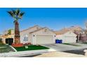 Front view of a house with a two-car garage and palm trees at 8113 Hercules Dr, Las Vegas, NV 89128