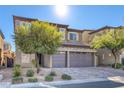 Two-story house with gray siding, stone accents, and a three-car garage at 87 Newton Ridge Way, Las Vegas, NV 89183