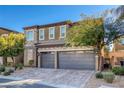 Two-story house with gray siding, stone accents, and a three-car garage at 87 Newton Ridge Way, Las Vegas, NV 89183