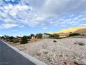 House with large windows, desert landscaping, and mountain backdrop at 1032 Morning Sun Way, Las Vegas, NV 89110
