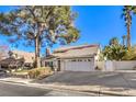Two-story house with a large tree, driveway, and landscaped yard at 3940 Spencer St, Las Vegas, NV 89119