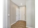Inviting hallway with tiled flooring, featuring neutral paint tones and white doors leading to various rooms at 43 E Agate Ave # 403, Las Vegas, NV 89123