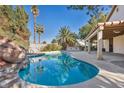 Inviting kidney-shaped pool with a waterfall feature and spacious patio at 4420 Resthaven Cir, North Las Vegas, NV 89032