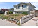 Side view of a two-story home, showing simple landscaping and a concrete barrier with decorative cutouts at 6324 Fairwood Ave, Las Vegas, NV 89107