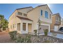 Two-story house with beige exterior, taupe garage door, and landscaping at 7808 License St, Las Vegas, NV 89131