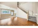 Living room with hardwood floors, high ceilings, and a staircase at 7808 License St, Las Vegas, NV 89131