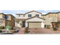 Inviting two-story home with manicured landscaping and a brick driveway leading to the garage at 12815 Alcores St, Las Vegas, NV 89141