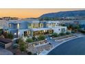 Aerial view of a modern gray home with desert landscaping, mountains in background at 14 Magic Stone Ln, Las Vegas, NV 89135