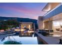 Luxury outdoor space with a zero-edge pool, sunken seating area, and dramatic lighting at 14 Magic Stone Ln, Las Vegas, NV 89135