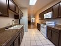 Kitchen with dark cabinets, granite counters, and white appliances at 1804 Discus Dr, Las Vegas, NV 89108