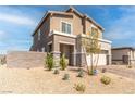 Beige two-story house with stone accents, landscaping, and a driveway at 230 Palisade Falls Ave, Henderson, NV 89015