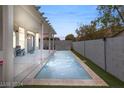 Long rectangular pool with covered patio and grassy backyard at 3940 Colonial Field Ave, North Las Vegas, NV 89031