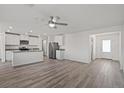 Open living room and kitchen with grey flooring and ceiling fan at 4253 Gold Desert St, North Las Vegas, NV 89032