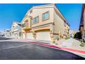 Exterior view of a modern townhouse with a two-car garage and well-maintained landscaping at 4710 Frasers Owl Ave # 103, North Las Vegas, NV 89084