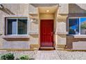 Red front door entry to a townhome with landscaping at 4710 Frasers Owl Ave # 103, North Las Vegas, NV 89084