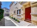 Red front door with a brick walkway and landscaping at 4710 Frasers Owl Ave # 103, North Las Vegas, NV 89084