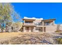 Two-story home with stucco exterior, balcony, and desert landscaping at 4780 Mack Ct, Pahrump, NV 89060