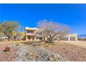 Two-story home with stucco exterior, attached garage, and desert landscaping at 4780 Mack Ct, Pahrump, NV 89060