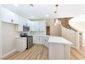 Modern white kitchen with an island and breakfast bar at 6529 Za Zu Pitts Ave # 102, Las Vegas, NV 89122