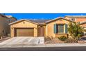 Tan house with brown garage door, teal shutters, and a landscaped yard at 6733 Violet Bluff Ct, North Las Vegas, NV 89084