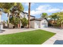 Two-story house with a three-car garage and lush landscaping at 6808 Rose Petal Ave, Las Vegas, NV 89130