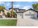 Two-story house with three-car garage and grassy front yard at 6808 Rose Petal Ave, Las Vegas, NV 89130