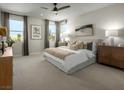 Bright main bedroom with plush carpeting and ceiling fan at 732 Icy Fjord Ln, Henderson, NV 89015